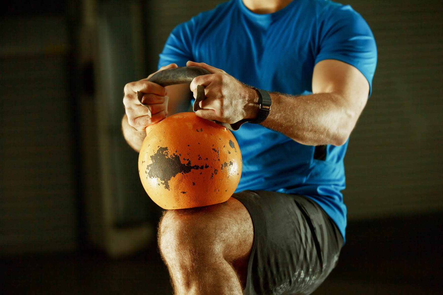 man using kettlebell on knee for workout