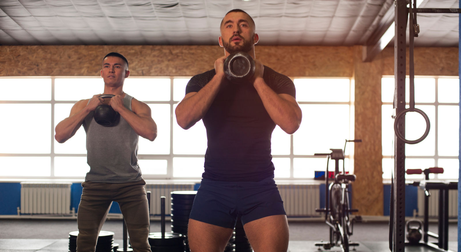 2 men working out with kettlebells